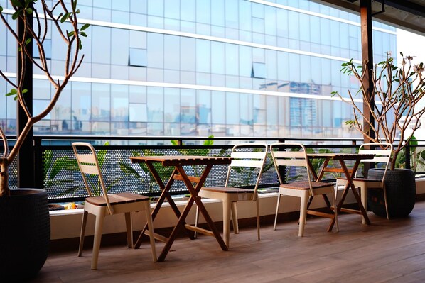 Un área de estar moderna al aire libre con vista a un edificio de vidrio.