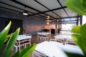 Un amplio espacio interior con mesas y sillas, una chimenea y vistas a través de un techo de cristal.