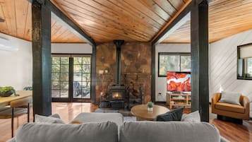 Una sala de estar acogedora con chimenea de piedra, televisor y un espacio de descanso confortable.