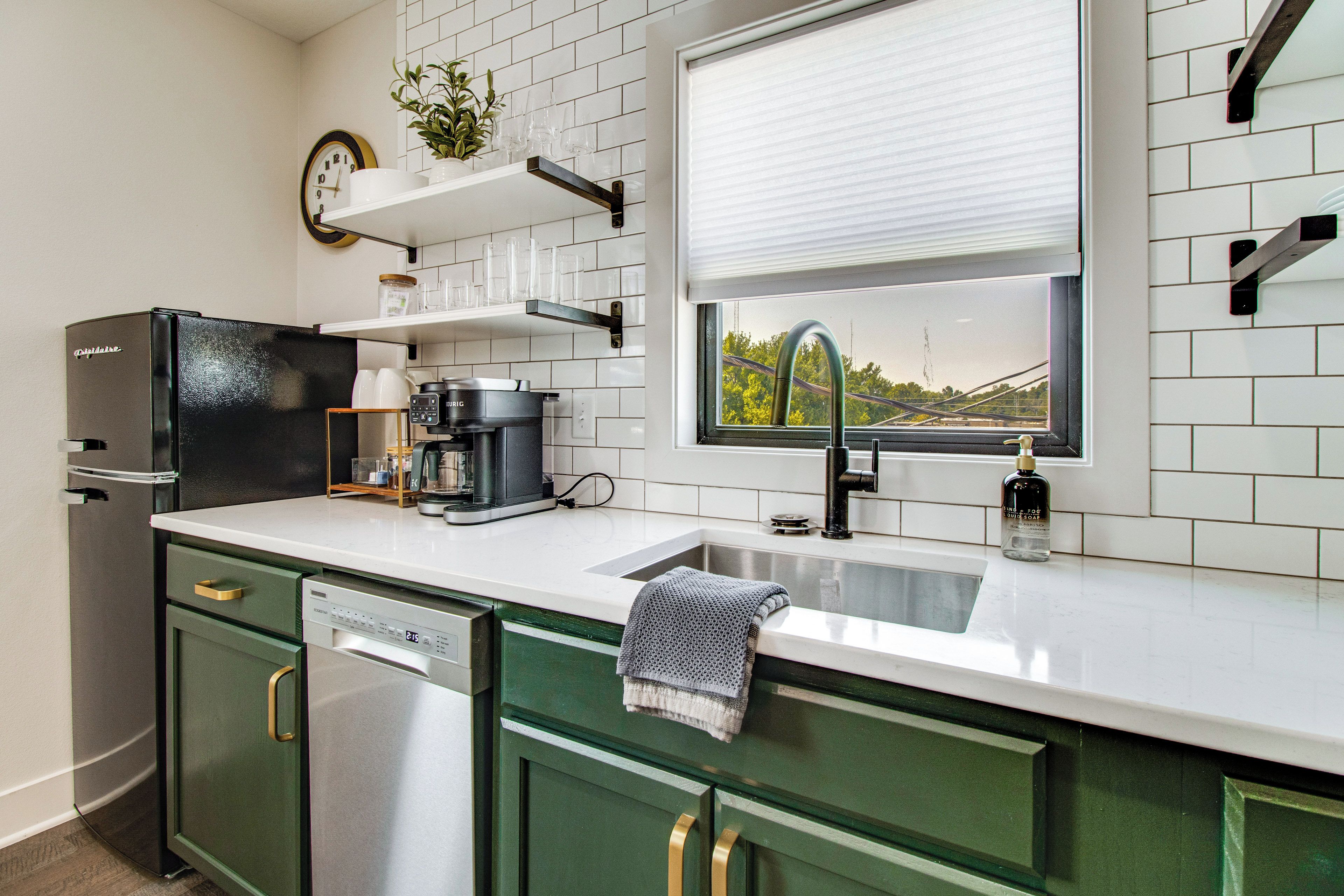 Una cocina moderna con lavavajillas, cafetera y ventana con vistas.