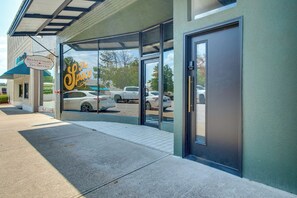 A building entrance with a glass door, a sign for 'The Space,' and a parking lot visible through the door. - Walk to Mountain Home Square: Remodeled Apt (Mountain Home)