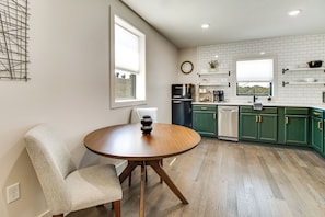 A modern kitchen with a round wooden table, green cabinets, and a built-in oven. - Walk to Mountain Home Square: Remodeled Apt (Mountain Home)