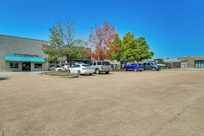 A parking lot with multiple cars, a building with a sign reading 'FirstSecurity,' and a clear blue sky. - Walk to Mountain Home Square: Remodeled Apt (Mountain Home)