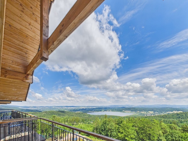 A wooden balcony with a view of a lake and forested landscape. - Kazalnica Family & Conference Resort with Pool & Restaurant by Solarento (Sosnówka)