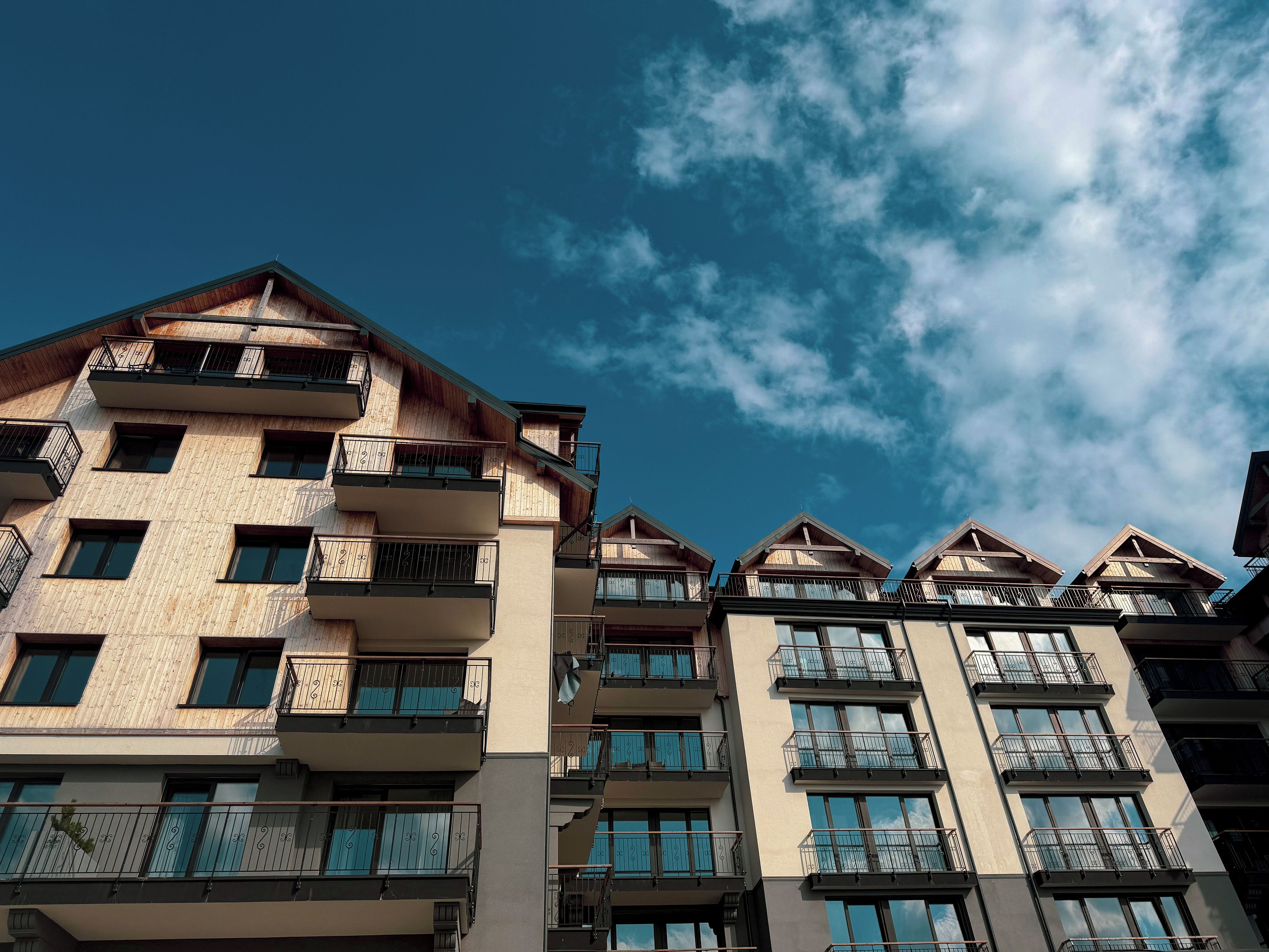 A multi-story residential building with balconies and large windows.