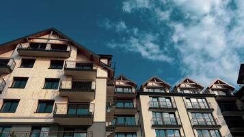 A multi-story residential building with balconies and large windows.