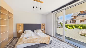Un dormitorio con una cama grande, un armario de madera, una mesita de noche y vistas al exterior.