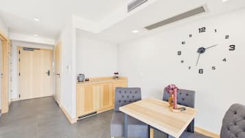 A modern kitchen with a wooden cabinet and a wall clock.