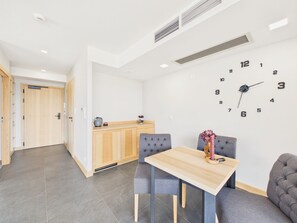 A modern kitchen with a wooden cabinet and a wall clock.
