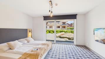 A bedroom with a bed, a window, and a view of a building.
