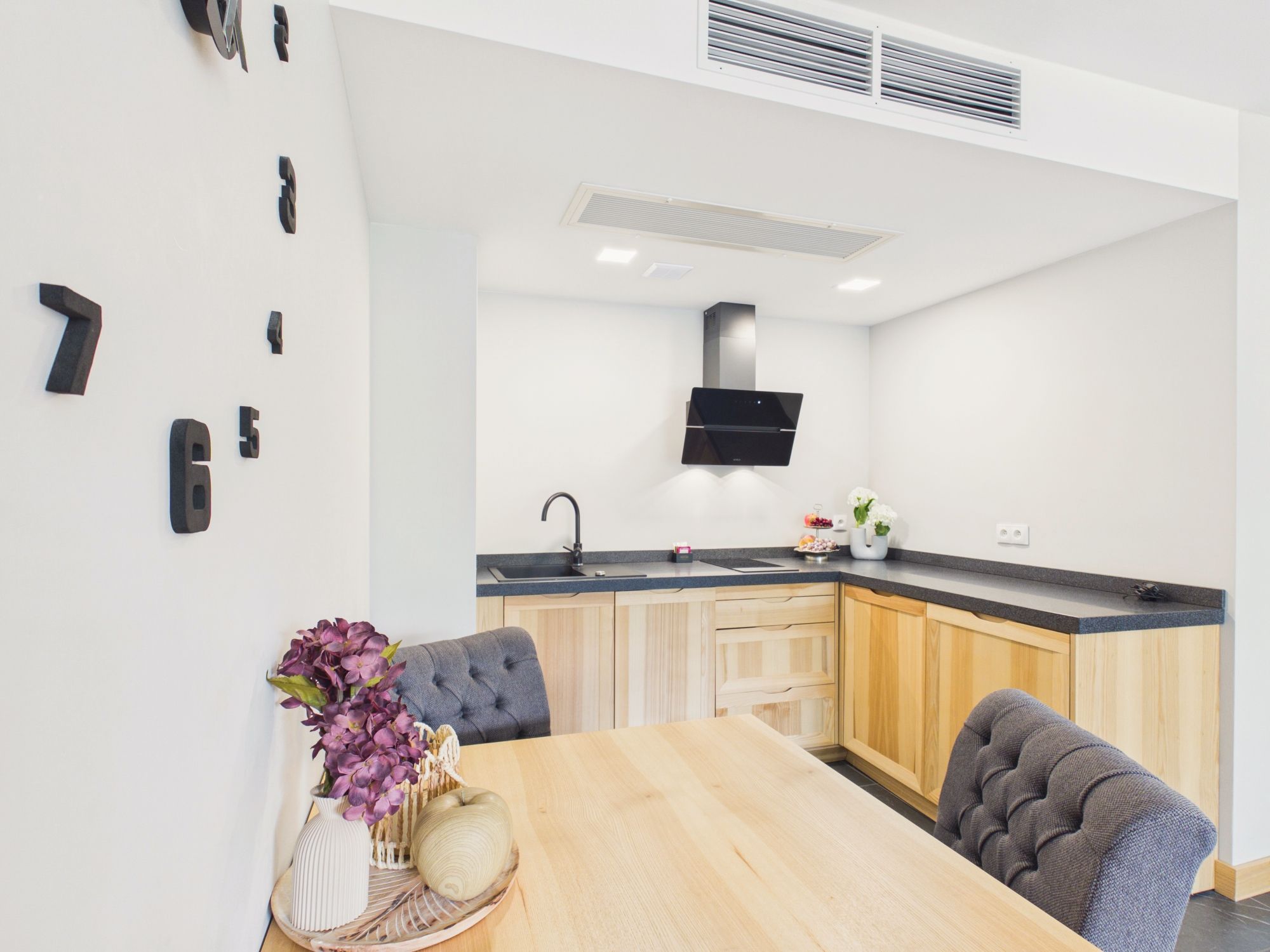Una cocina moderna con estufa integrada, un lavamanos y un comedor con mesa y sillas.