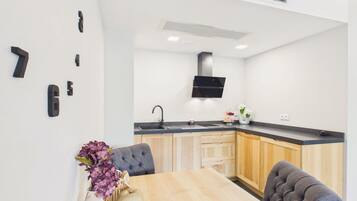 Una cocina moderna con estufa integrada, un lavamanos y un comedor con mesa y sillas.