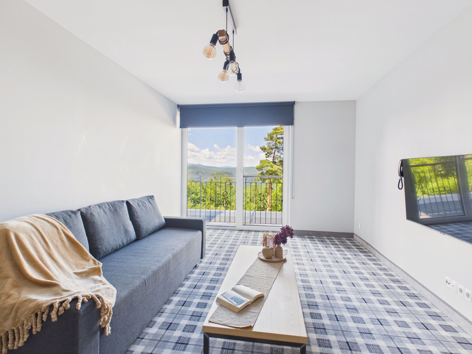 Una sala de estar moderna con un sofá, una mesa de centro y vistas a un balcón con barandilla.