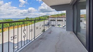Un balcón con vistas a un paisaje verde y un cielo despejado.