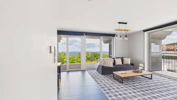 Una sala de estar moderna con un sofá, una mesa de centro y ventanas amplias con vistas a zonas verdes.