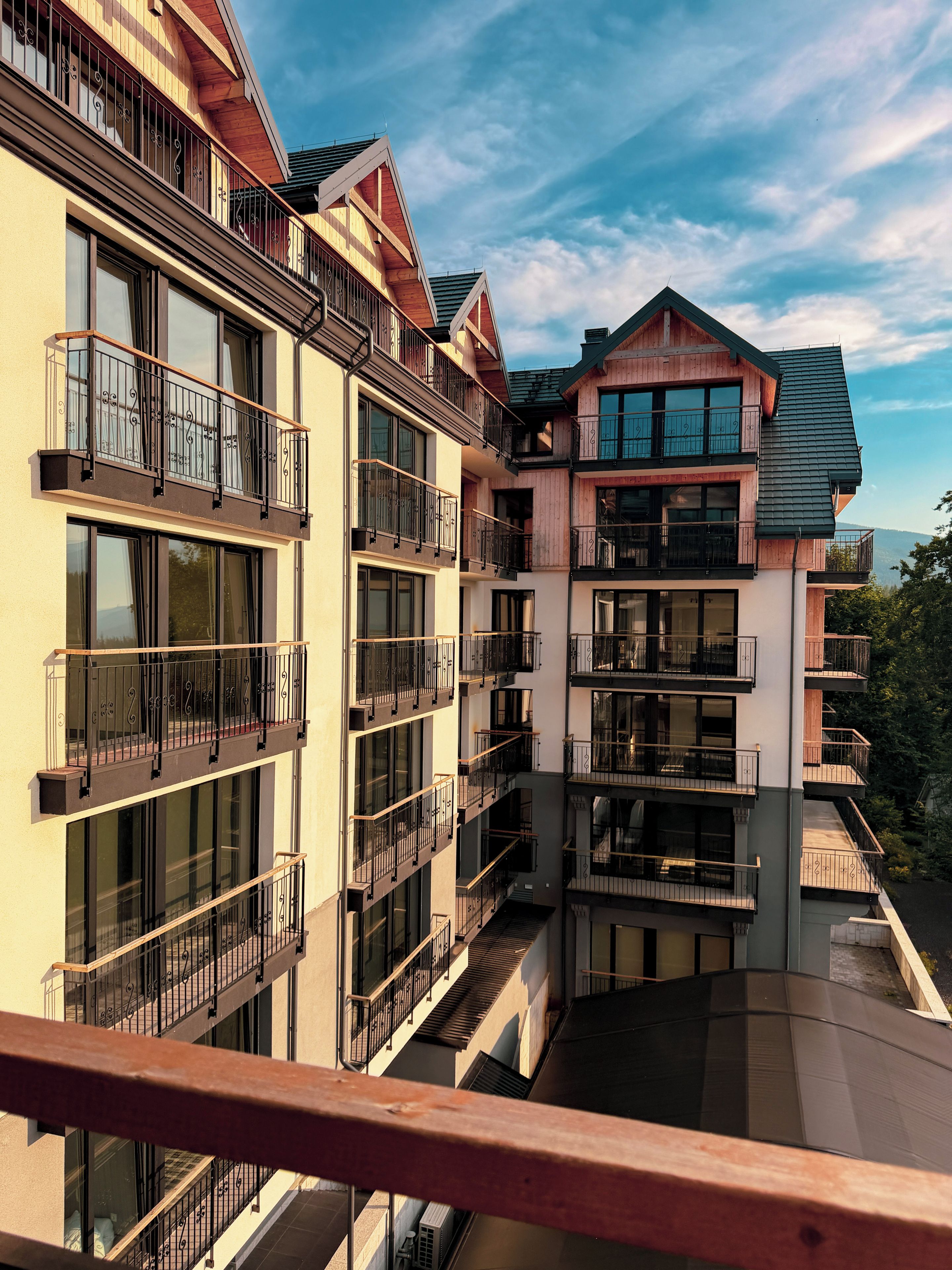 Un edificio de varios pisos con balcones, ventanas amplias y un cielo despejado.