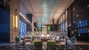 A modern lobby with a central seating area, a patterned wall, and a decorative ceiling feature. - Grand Skylight InternationalHotelXinfeng (Ganzhou)