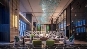 A modern lobby with a central seating area, a patterned wall, and a decorative ceiling feature. - Grand Skylight InternationalHotelXinfeng (Ganzhou)