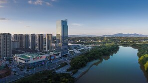 Un edificio moderno de gran altura, rodeado por un río y un paisaje montañoso.