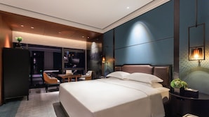 A modern hotel room with a large bed, a desk, and a seating area. - Grand Skylight InternationalHotelXinfeng (Ganzhou)