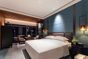 A modern hotel room with a large bed, a desk, and a seating area. - Grand Skylight InternationalHotelXinfeng (Ganzhou)
