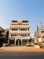 Un edificio de varios pisos con una entrada central, balcones y un letrero que dice 'Handloom House'.
