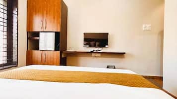 Un dormitorio con cama, armario de madera, televisor e iluminación en el techo.