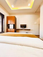 Un dormitorio con cama, armario de madera, televisor e iluminación en el techo.