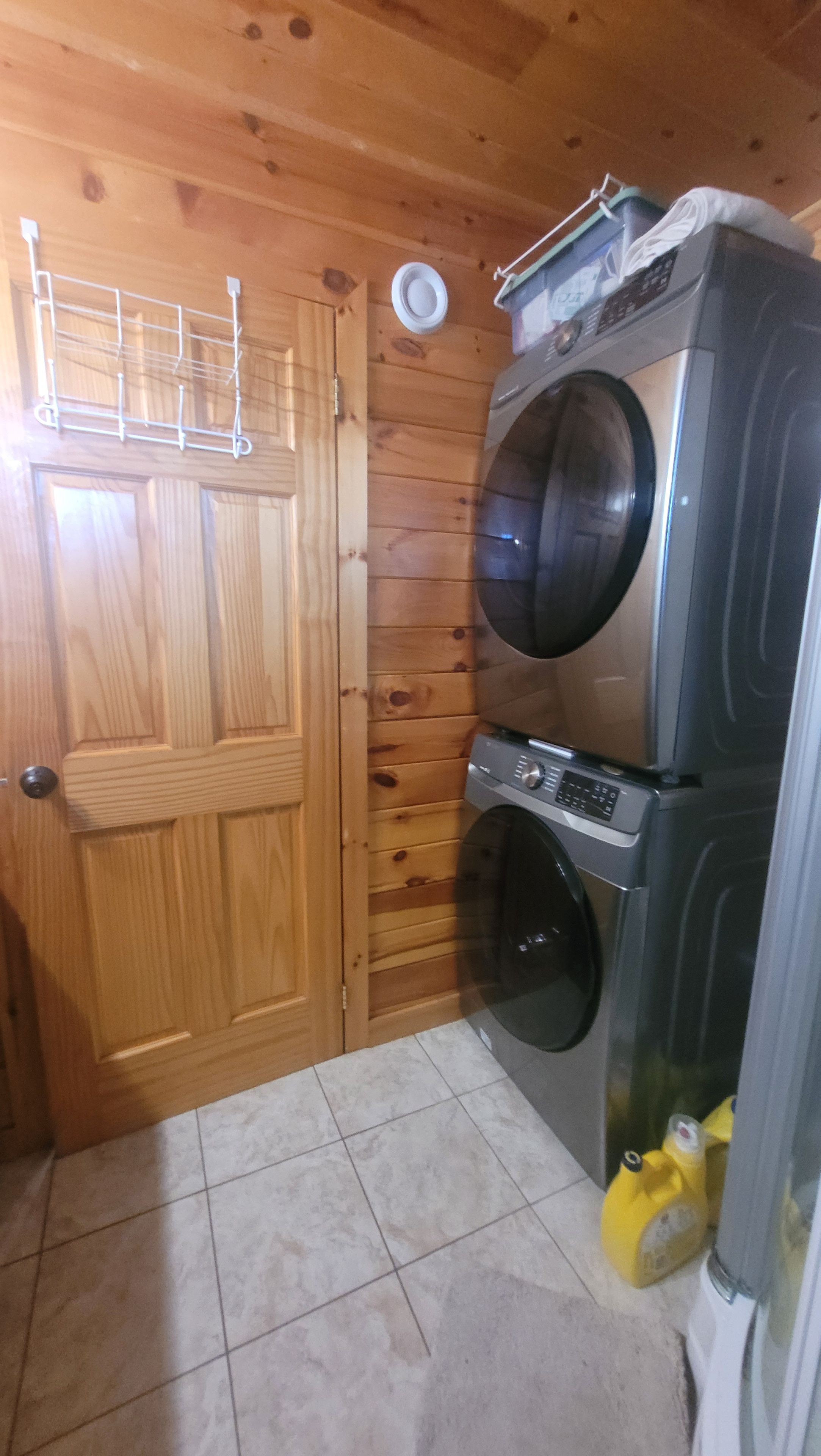 A laundry room with a wooden door, a washing machine, and a dryer.