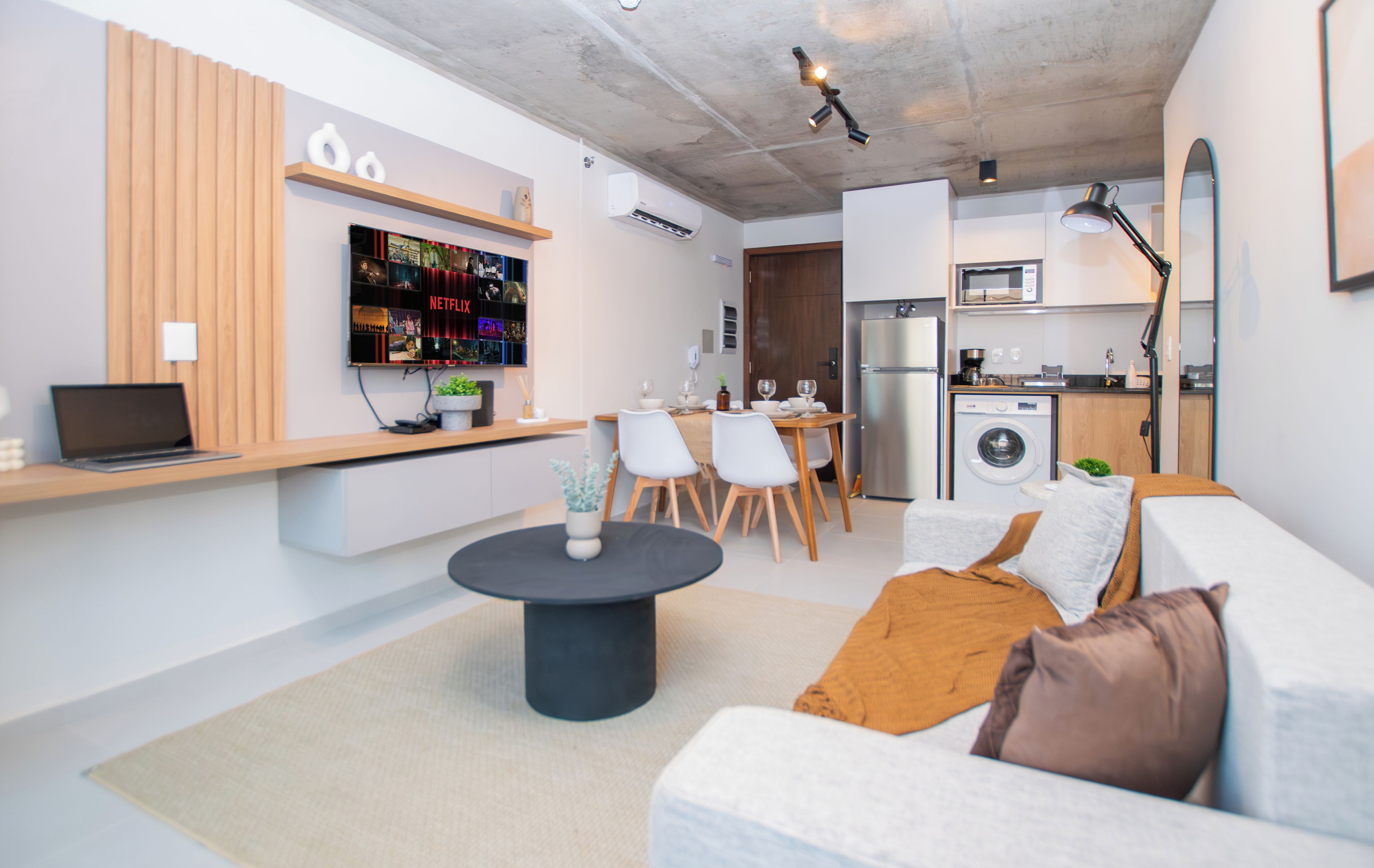 Ein modernes Wohnzimmer mit einer Couch, einem Couchtisch und einem Fernseher, der Netflix-Inhalte zeigt.