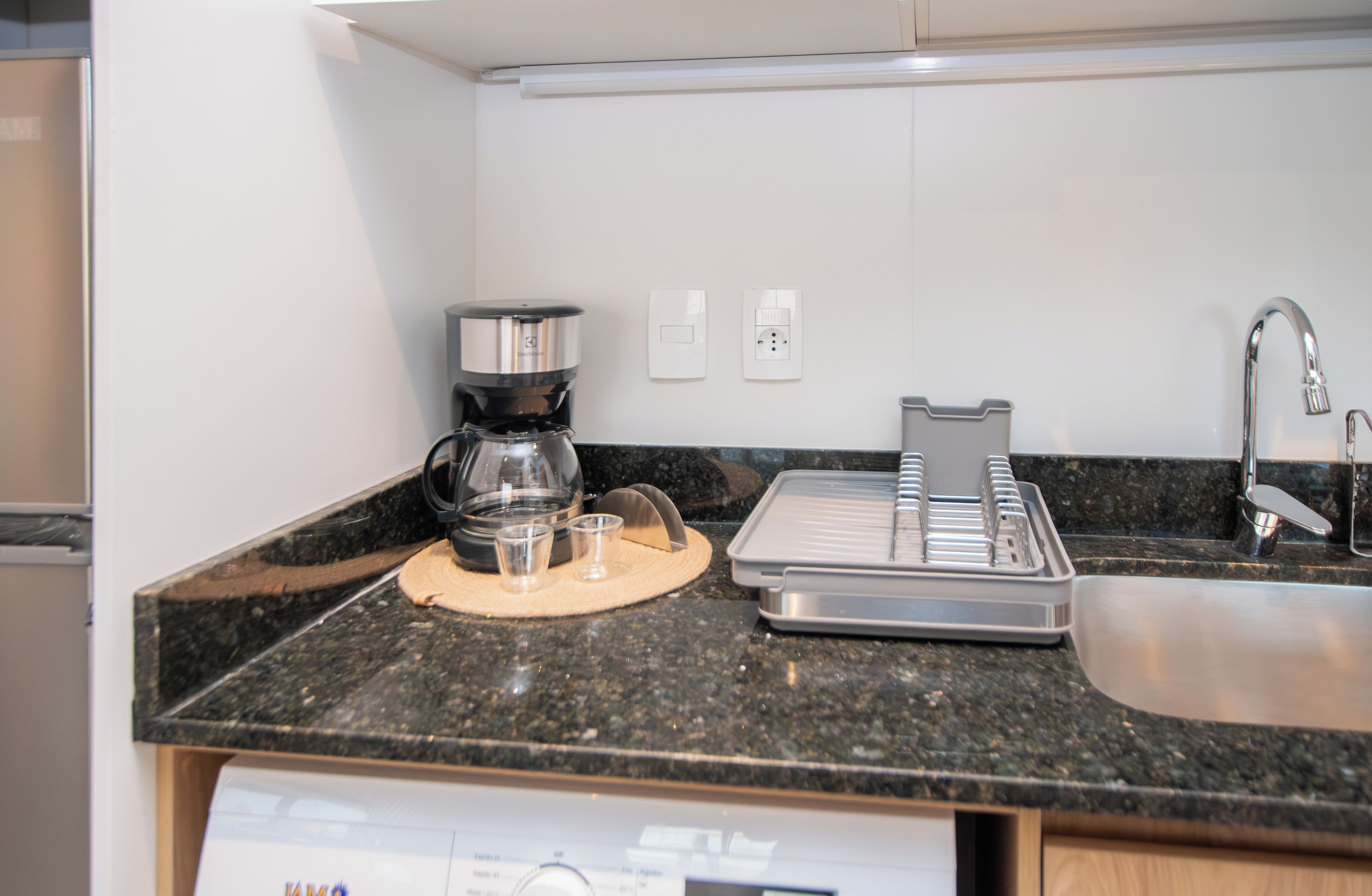 Una kitchenette compacta equipada con cafetera, tostadora y pileta.