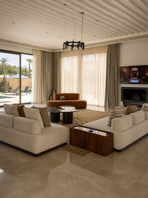 A spacious living room with a large sofa, a coffee table, and a fireplace.