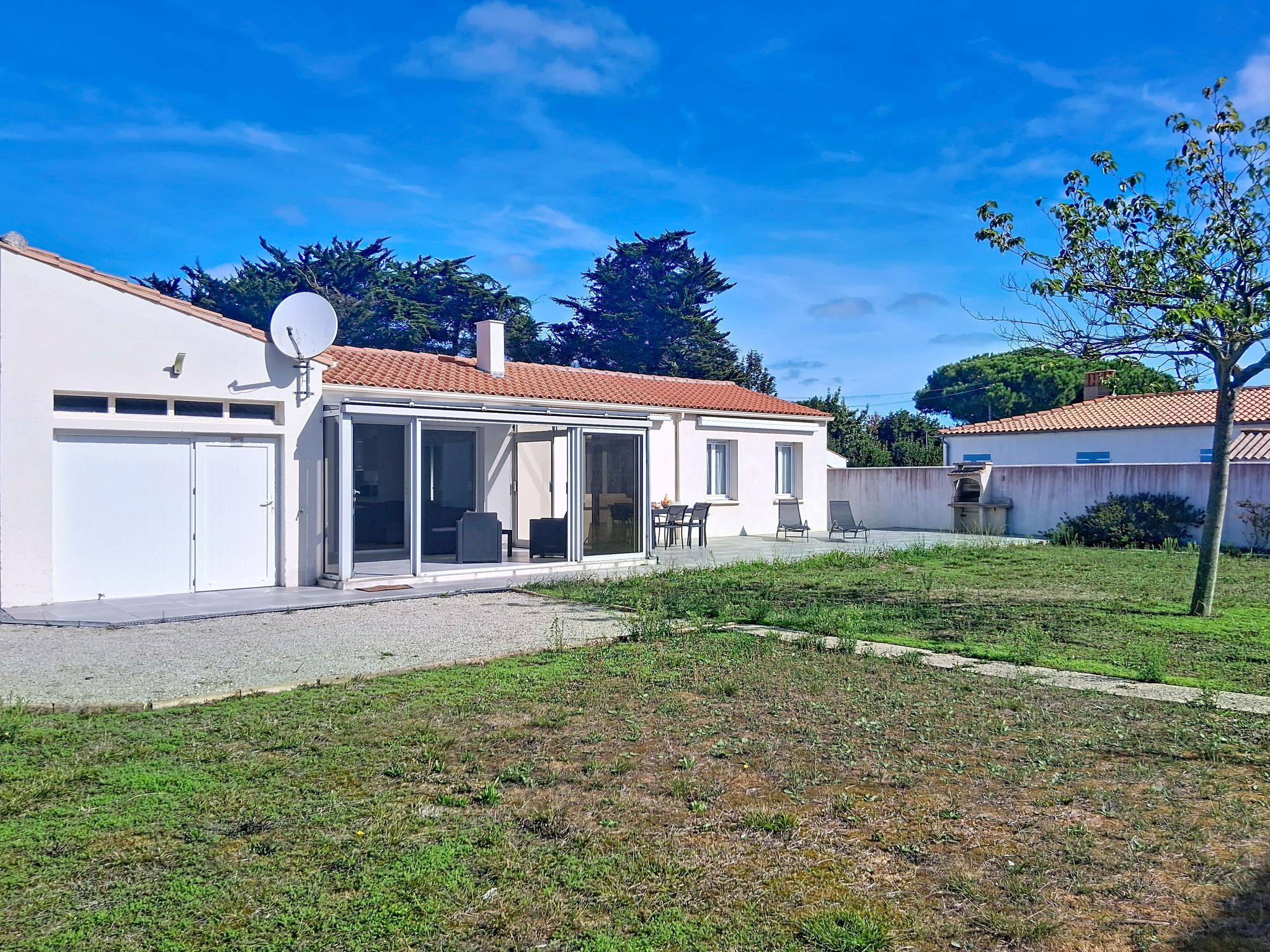 A modern house with a patio, a satellite dish, and a well-maintained lawn.