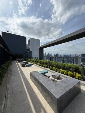 Eine Terrasse im Freien mit Sitzgelegenheiten und Blick auf die Stadt.