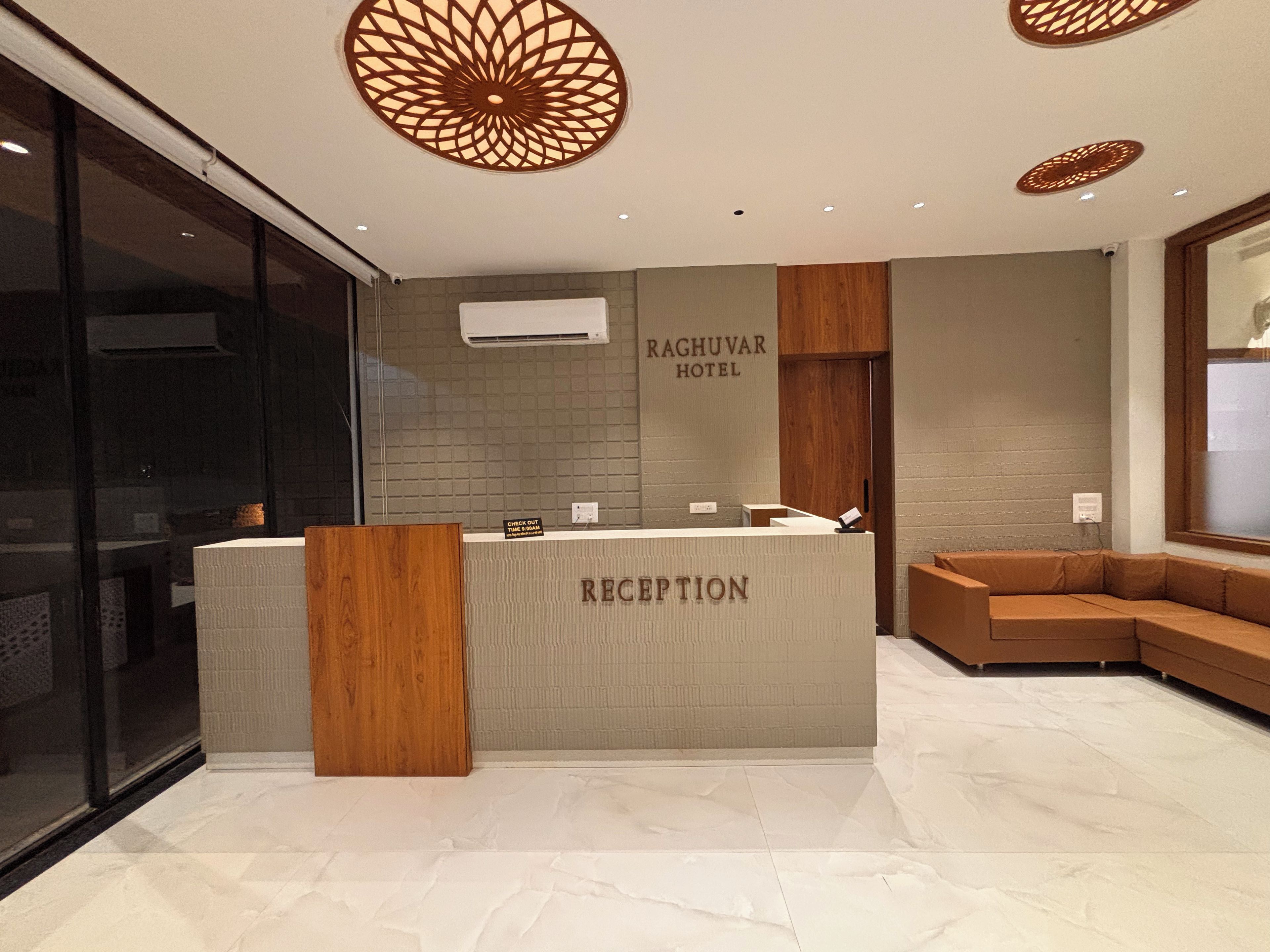 A reception area with a reception desk, a check-out sign, and a seating area with a sofa.