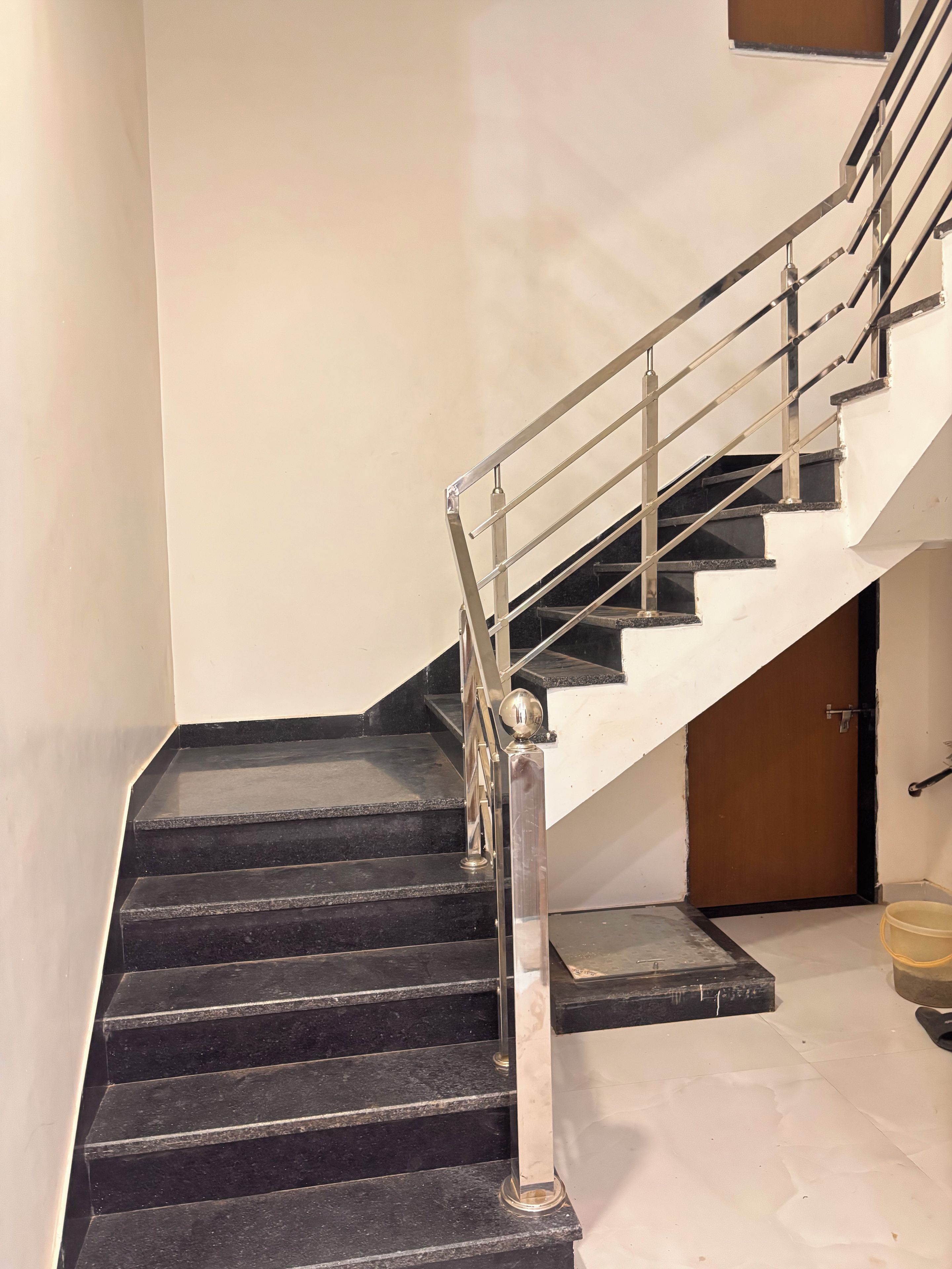 Eine Treppe mit Metallgeländer und schwarzen Stufen.