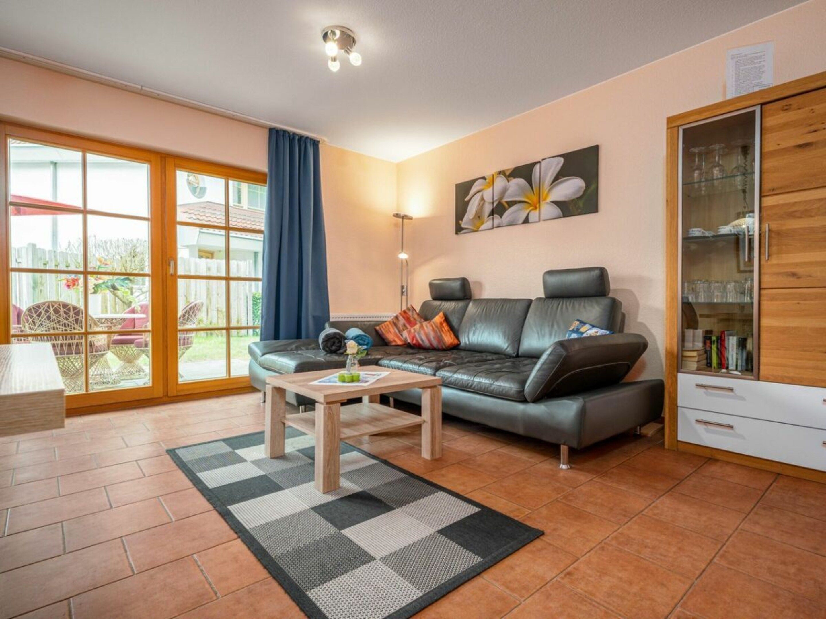 Ein Wohnzimmer mit einer Couch, einem Couchtisch und einer Vitrine.