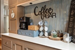 Un espace bar à café équipé d’une machine à café, d’un appareil pour faire mousser le lait et de différents récipients pour le café.