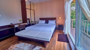 A modern bedroom with a large bed, wooden flooring, a ceiling fan, and a view of the outdoors. - The Treetop Escape by VOYE HOMES (Peermade)