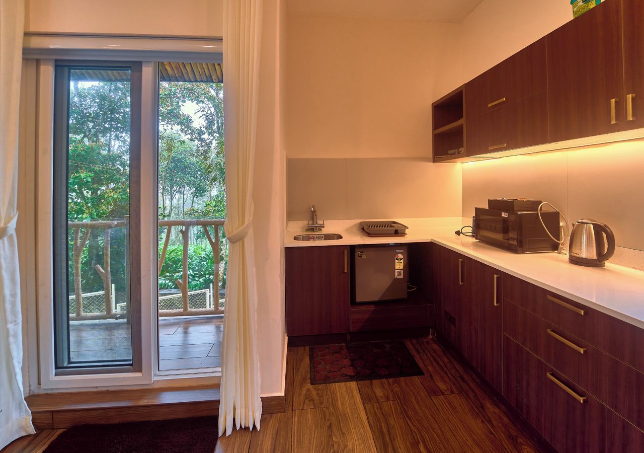 A compact kitchen with a built-in microwave, a coffee maker, and a small refrigerator.