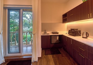 A compact kitchen with a built-in microwave, a coffee maker, and a small refrigerator. - The Treetop Escape by VOYE HOMES (Peermade)