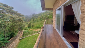 A modern building with a balcony overlooking a lush green landscape.