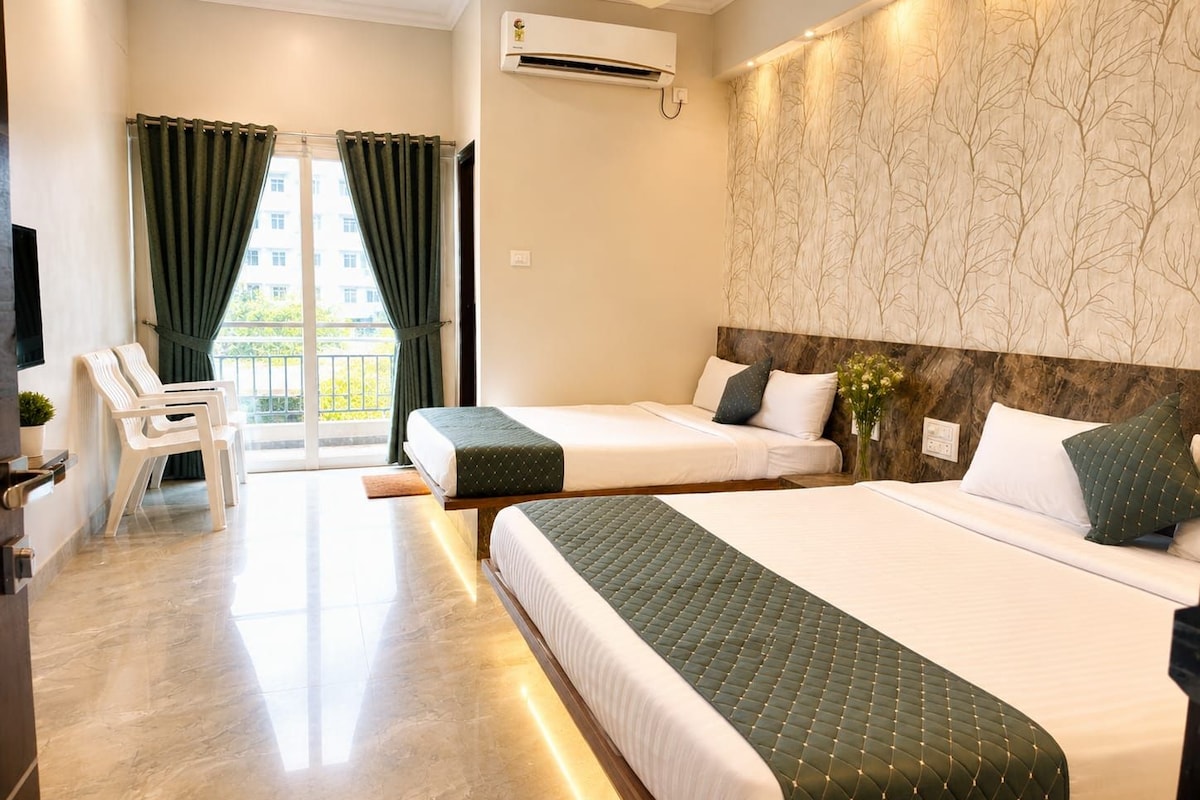 A hotel room with two beds, a balcony, a TV, and an air conditioning unit.