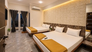 Een hotelkamer met twee bedden, een plafondventilator, een airconditioning en uitzicht door een glazen deur.