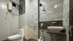 Een moderne badkamer met toilet, douche en wastafel.
