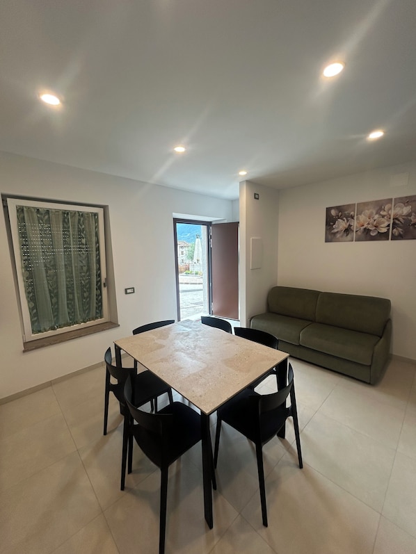 Un coin repas avec une table et des chaises, un canapé et un tableau accroché au mur.