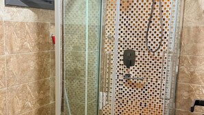 Un bagno con doccia vetrata, lavandino e WC.