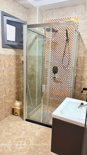 A bathroom with a glass-enclosed shower, a sink, and a toilet. - ✨ Elegant 2-bedroom apartment with a terrace in Riviera Faya (Abidjan)