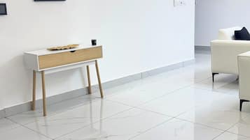 A modern interior with a white console table, a sofa, and a large mirror on the wall.