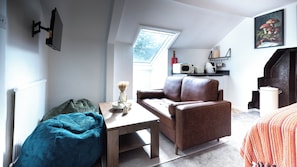 A cozy living room with a brown leather sofa, a blue bean bag, and a wooden coffee table. - The Stanley Arms Hotel by Guestz (Seascale)